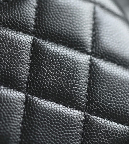 Close-up of black quilted leather panel with stitched seams