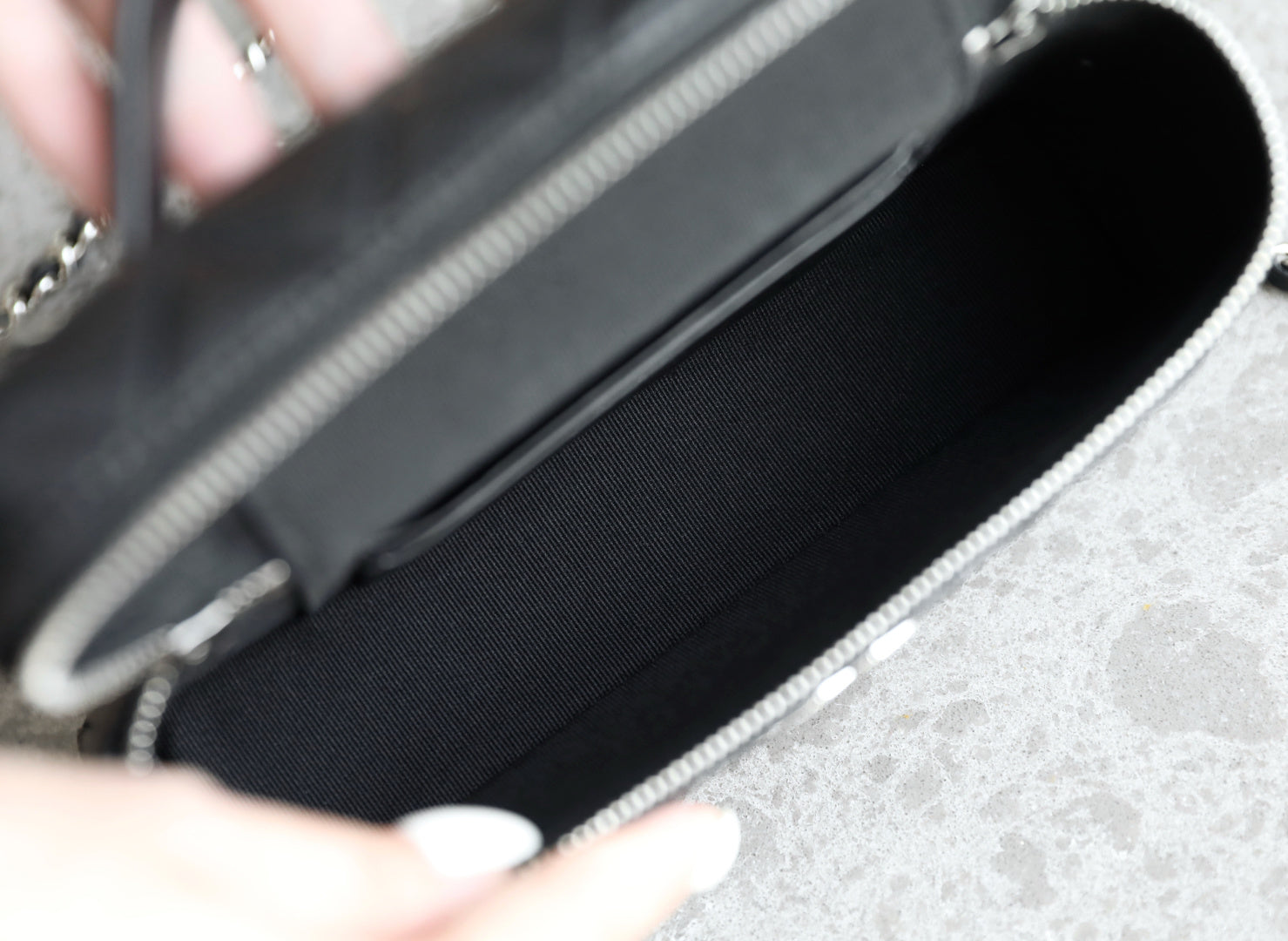 Chanel handbag interior with dark lining and open zipper pocket, black