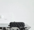 Chanel quilted handbag side view with chain strap and zipper top, black