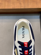 Unisex sneaker tongue view with Prada text and red logo patches on navy-and-white upper