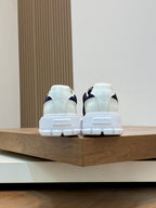 Pair of unisex sneakers from heel view in white and navy with white rubber sole