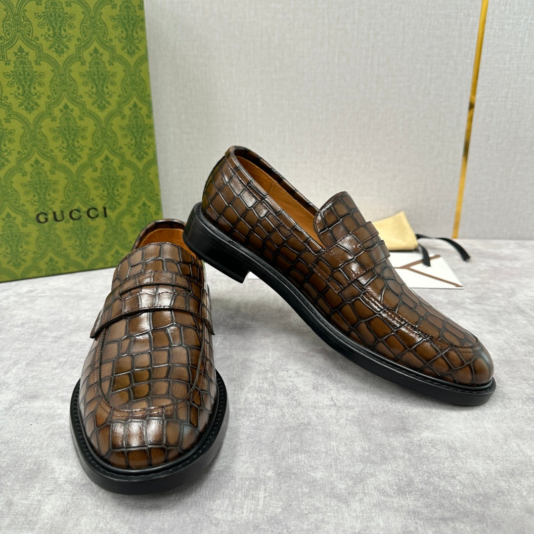 Brown crocodile-embossed Gucci loafers with strap across top and low block heel