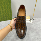 Gucci brown crocodile-embossed loafer with rounded apron and strap across vamp