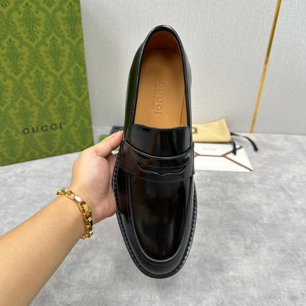 Unisex black leather loafer with strap top and tan insole, front view