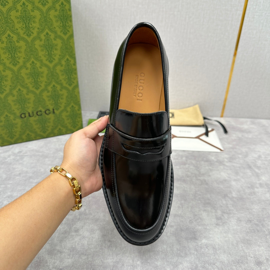Unisex black leather loafer with strap top and tan insole, front view