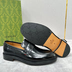 Unisex black leather loafers with outsole visible and strap with buckle detail
