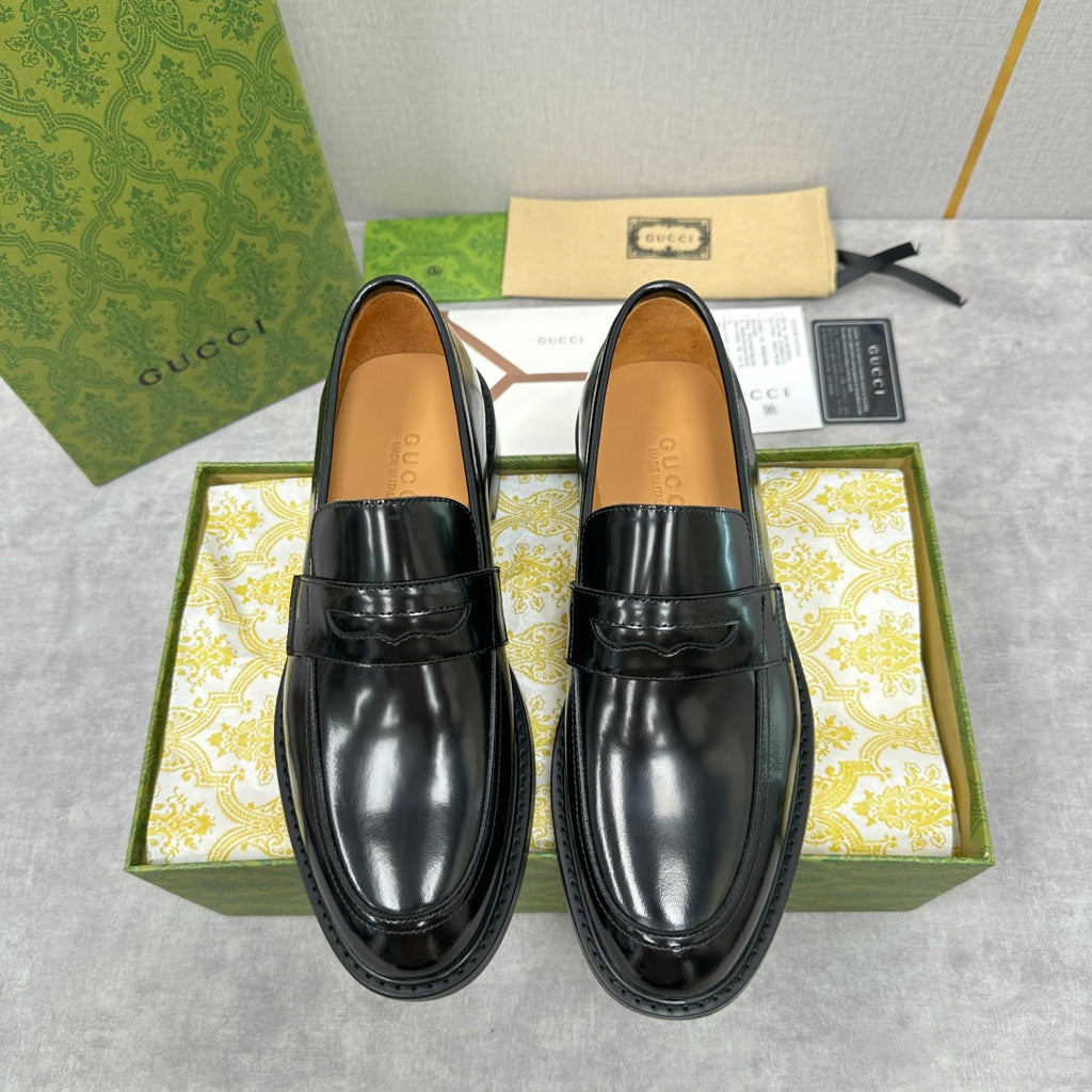 Unisex Gucci black leather loafers with glossy finish and strap detail