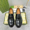 Unisex Gucci black leather loafers with glossy finish and strap detail