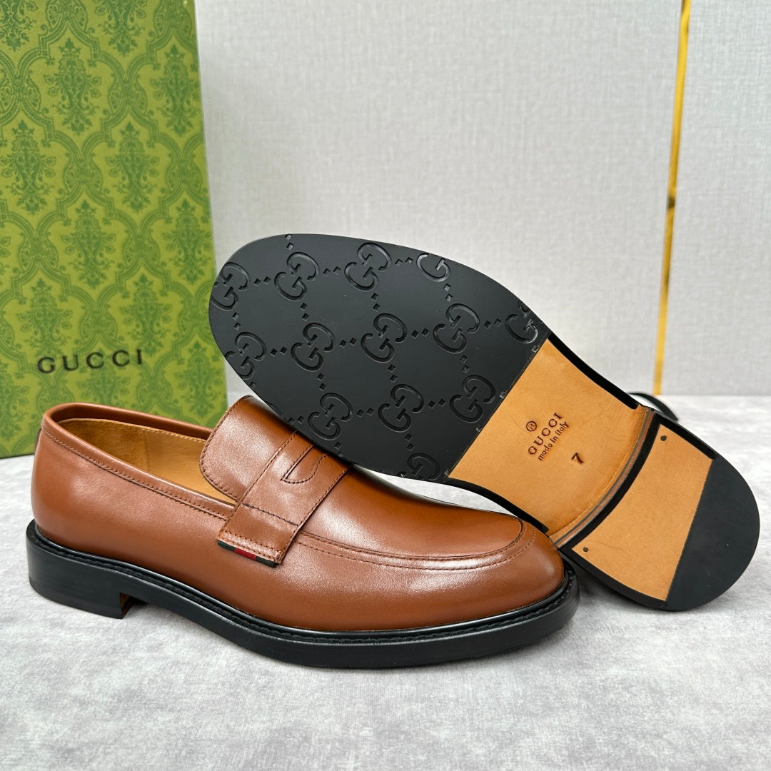 Brown leather loafer with embossed logo outsole and penny strap upper