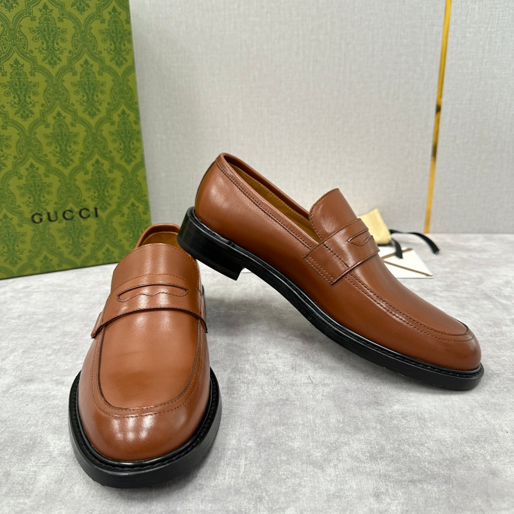 Brown leather slip-on loafer with penny strap and black rubber sole