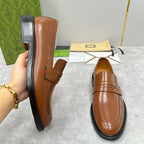 Brown leather Gucci loafer with penny strap, stitched seam, and rubber sole