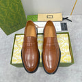 Brown leather Gucci unisex loafer with penny strap and black rubber sole
