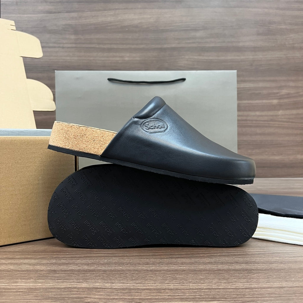 Black leather slide sandal with tan cork sole, stacked on textured base
