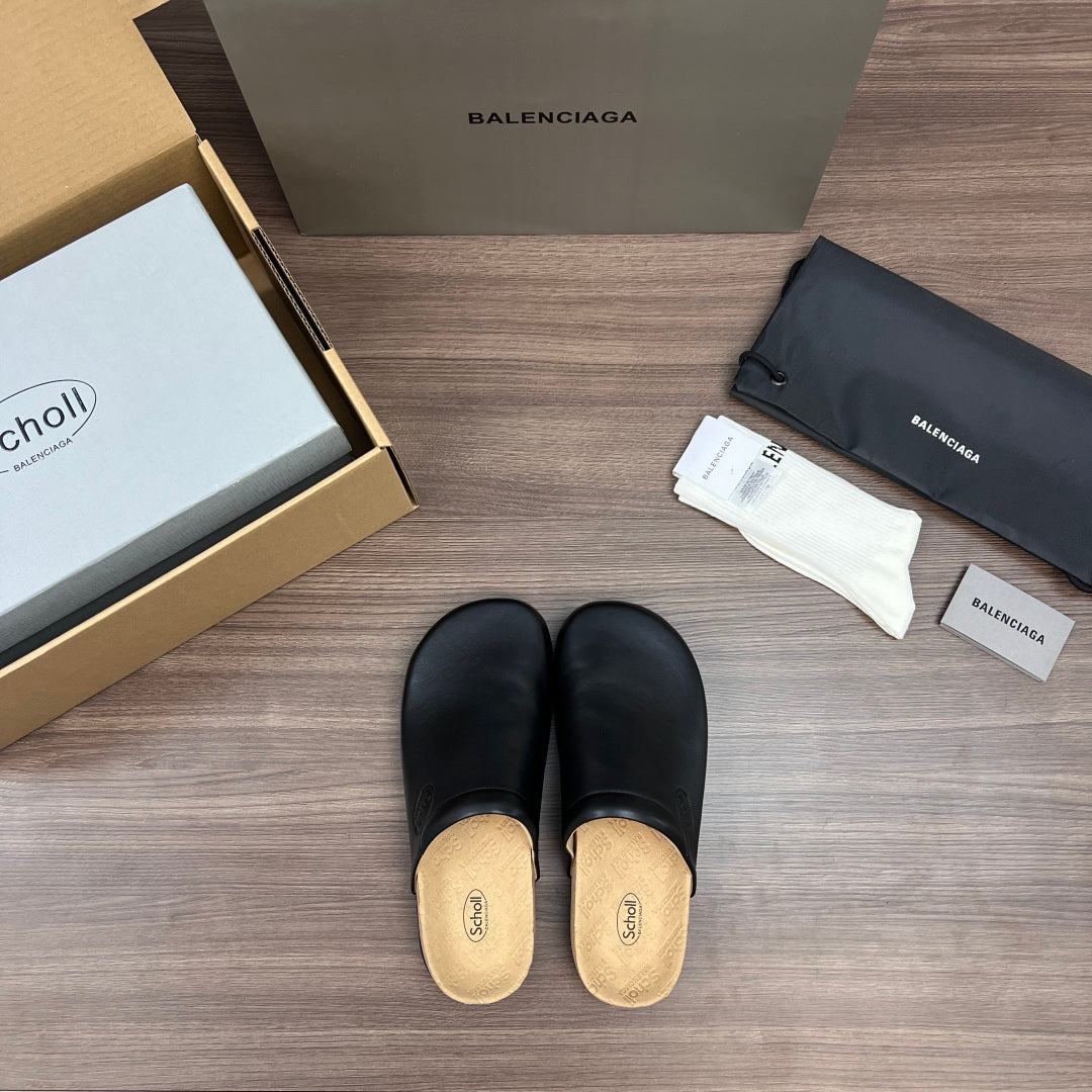Pair of black slip-on slide sandals with tan cork insoles and rounded toe