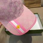 Gucci pink cap close-up showing GG monogram, striped band, and gold bee