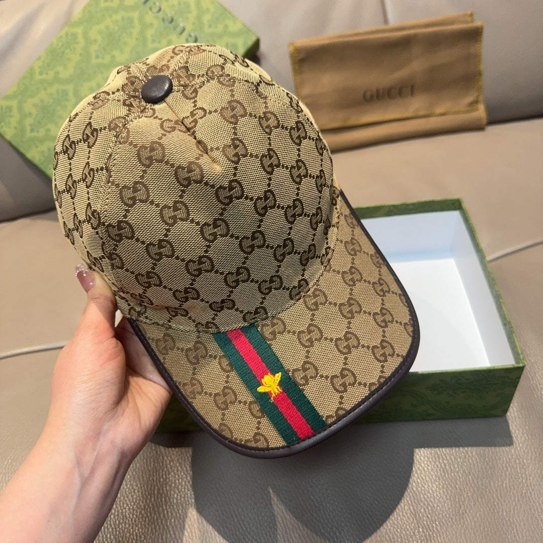 Gucci tan baseball cap with GG pattern and green/red stripe with yellow star, handheld view