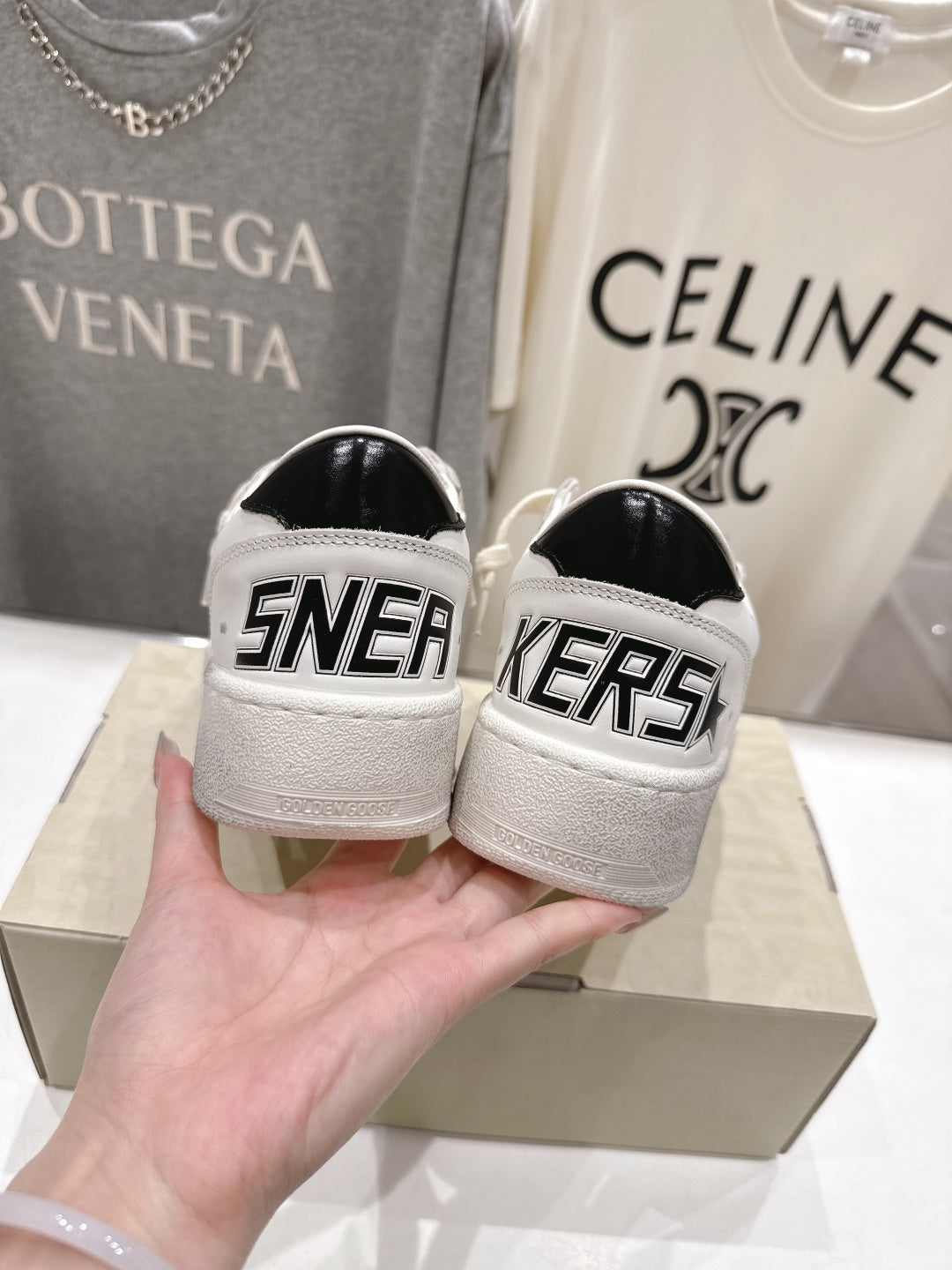 White sneakers with black heel panels and bold 'SNEAKERS' lettering