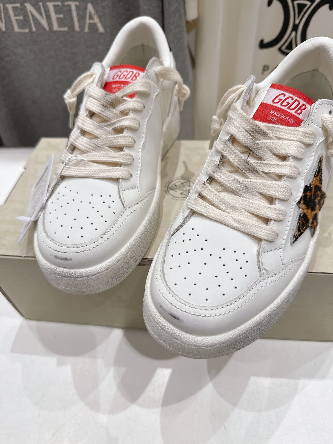 Pair of white lace-up sneakers with perforated toe and textured rubber sole