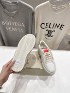 White sneakers with patterned rubber outsole and lace-up front