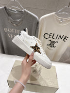 White lace-up sneakers with leopard side trim and small black detail near laces