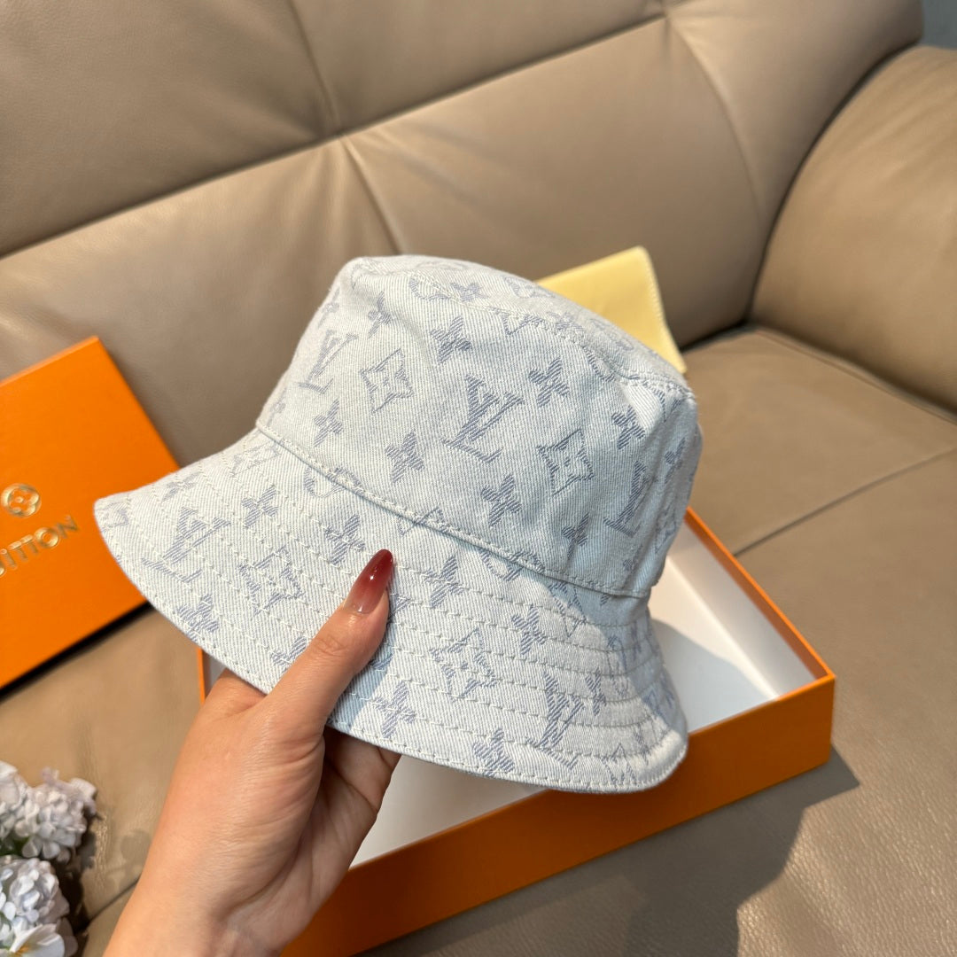 Louis Vuitton bucket cap in light blue with monogram print, held by hand