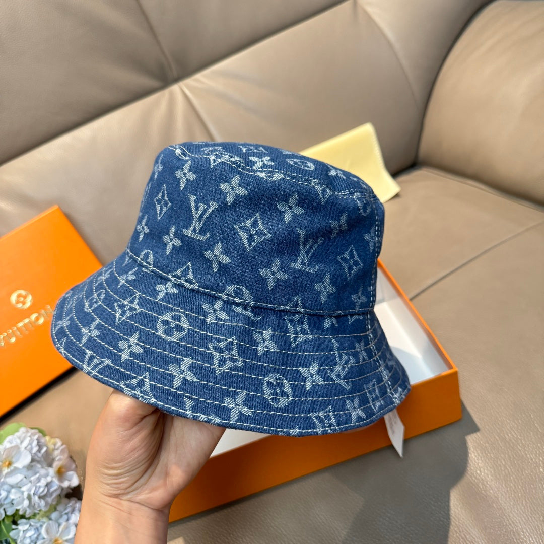 Louis Vuitton denim-blue monogram bucket hat, front view held in hand.