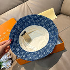 Louis Vuitton denim-blue monogram bucket hat with interior side tag visible.