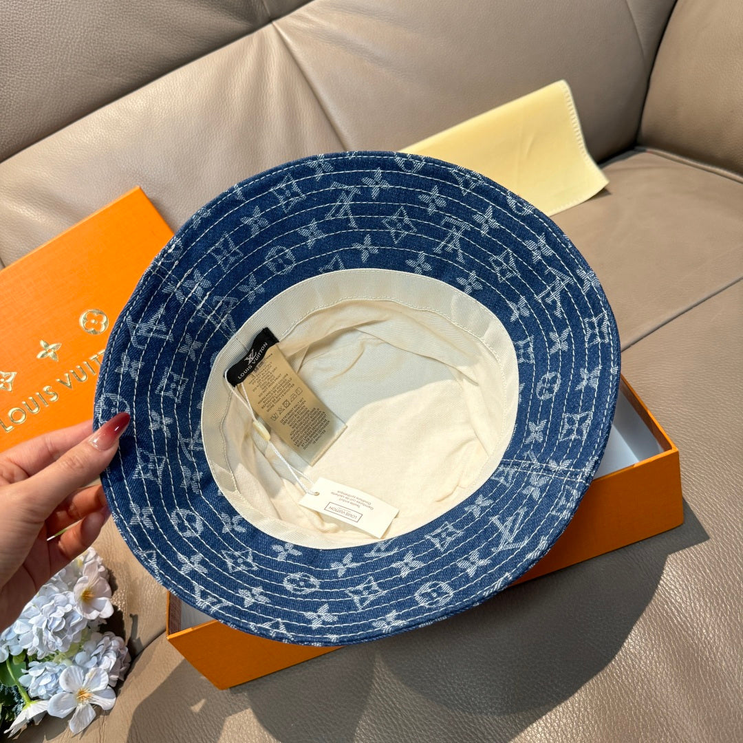 Louis Vuitton denim-blue monogram bucket hat with interior side tag visible.