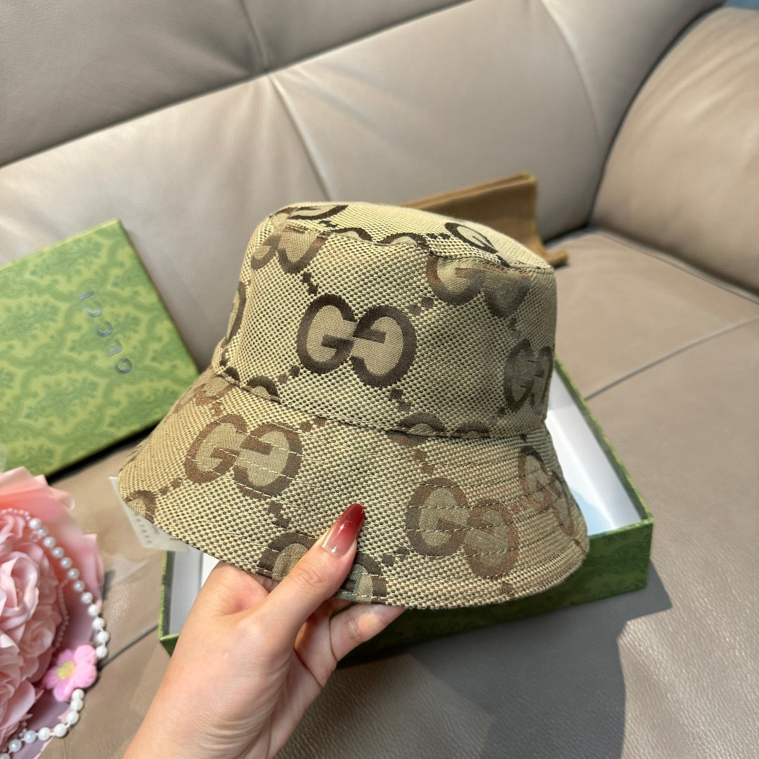 Tan GG monogram bucket hat with curved brim and stitched crown seam, held up