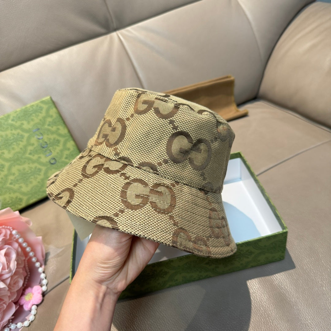 Tan GG monogram bucket hat with side profile and curved brim, held by hand