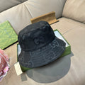 Gucci bucket hat in dark fabric with repeating GG monogram pattern.