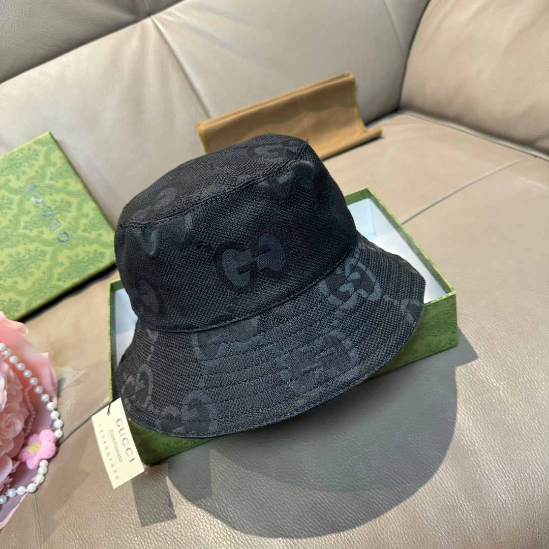 Gucci bucket hat in dark fabric with repeating GG monogram pattern.