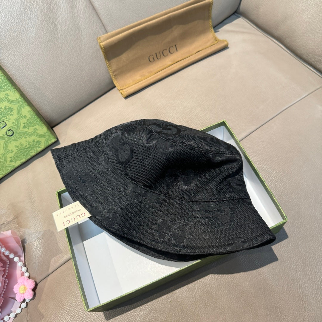 Gucci bucket hat in dark GG monogram fabric, folded flat on display surface.