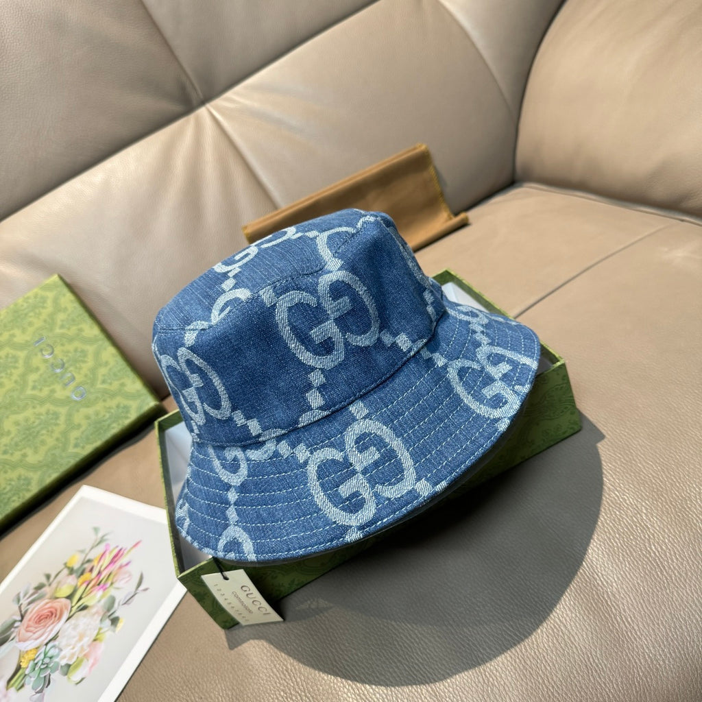 Gucci blue denim bucket cap with white GG logo pattern and stitched brim.
