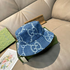 Gucci blue denim bucket cap with white GG logo pattern and stitched brim.