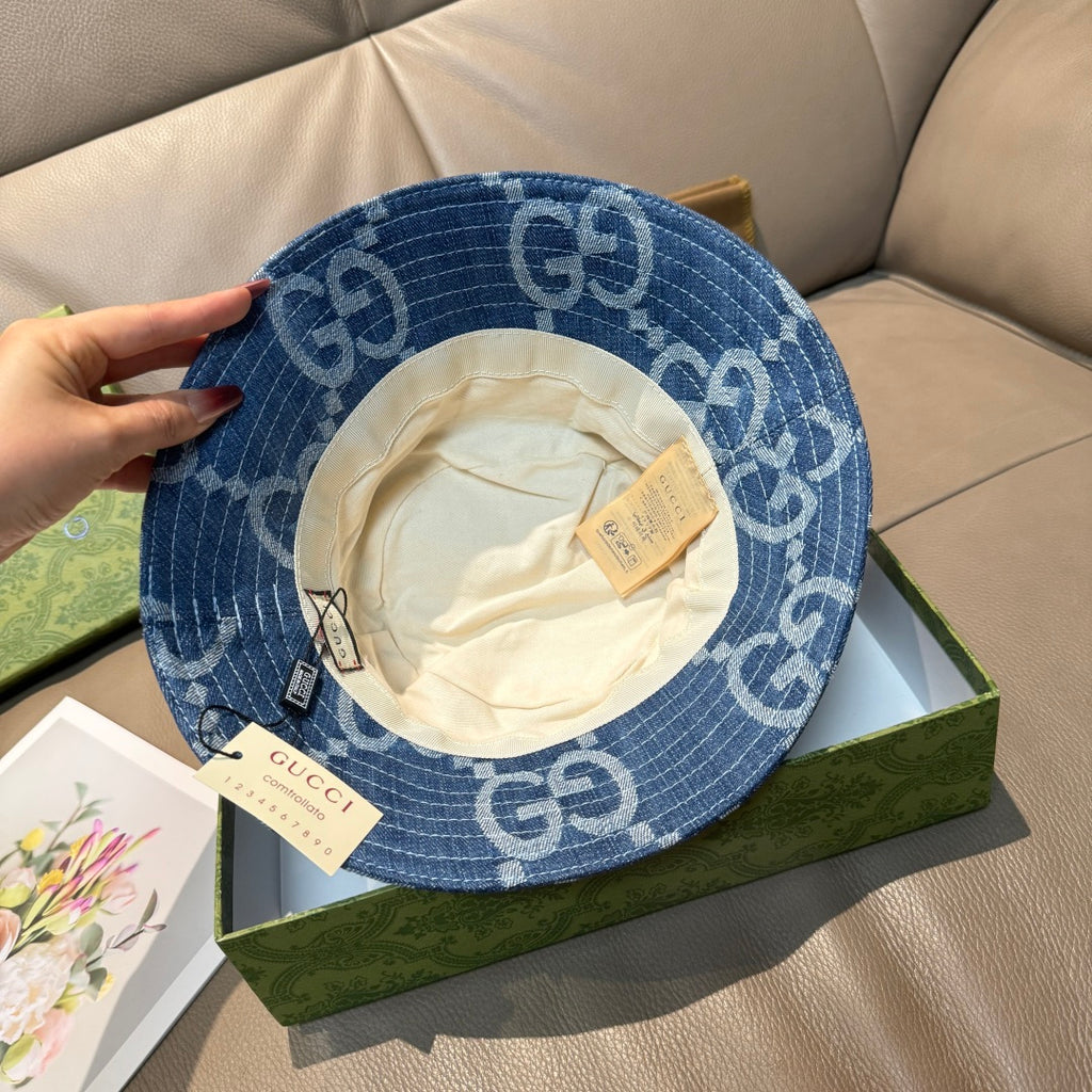 Gucci blue GG-print bucket cap with white inner lining and adjustable strap tags.
