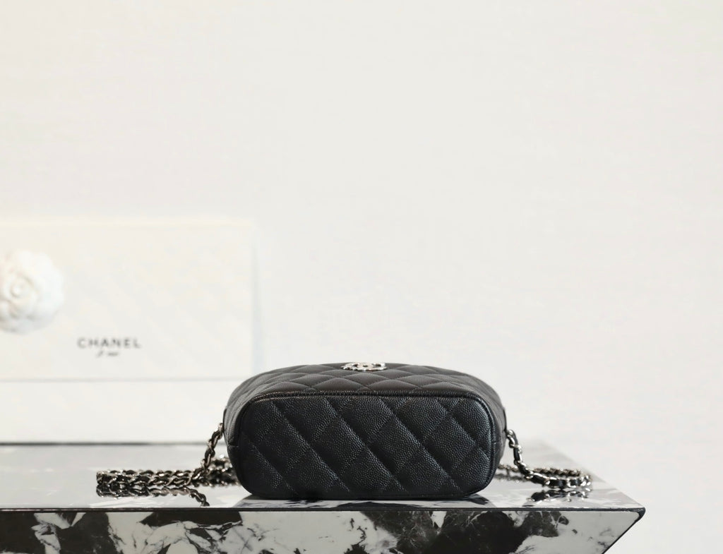 Black quilted mini handbag with top zipper and chain strap, back view