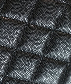 Quilted black leather handbag texture detail with diamond stitching