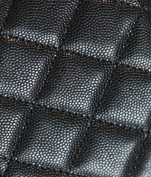 Quilted black leather handbag texture detail with diamond stitching