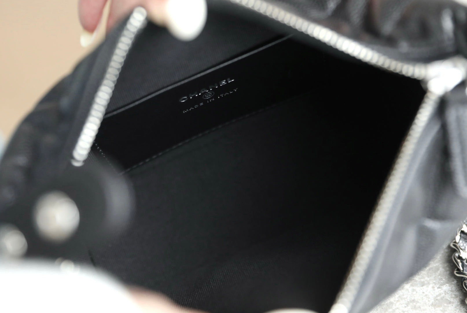 Black handbag interior with logo stamp, open top with chain strap
