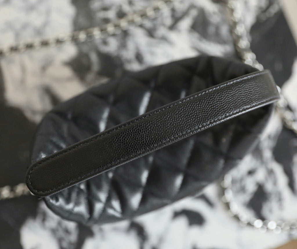 Black leather shoulder strap with silver chain; quilted bag body beneath