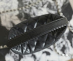 Black leather shoulder strap with silver chain; quilted bag body beneath