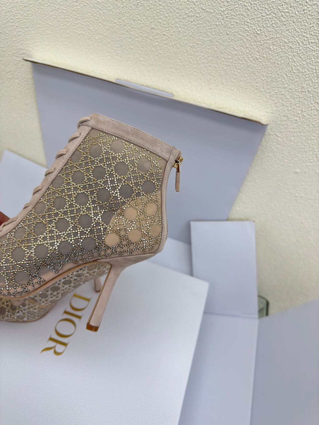 Women’s ankle boot side view with beige geometric pattern and zip detail