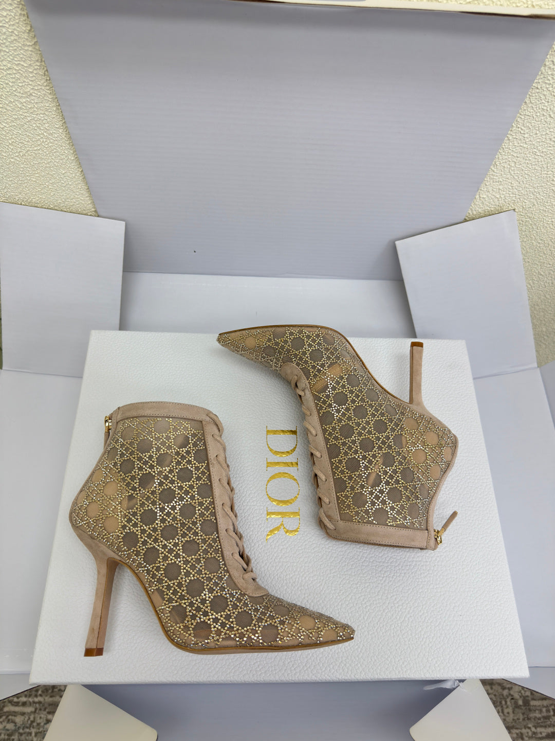 Women’s heeled ankle boots, beige geometric pattern, pair on display