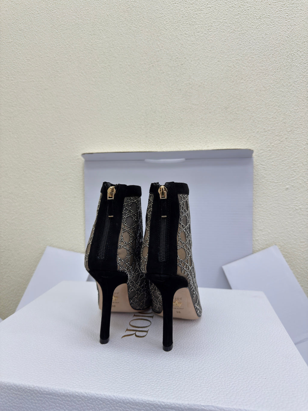 Women’s lace-up ankle boots with monogram print and gold buckle accents, stiletto heel
