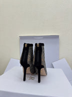 Women’s lace-up ankle boots with monogram print and gold buckle accents, stiletto heel