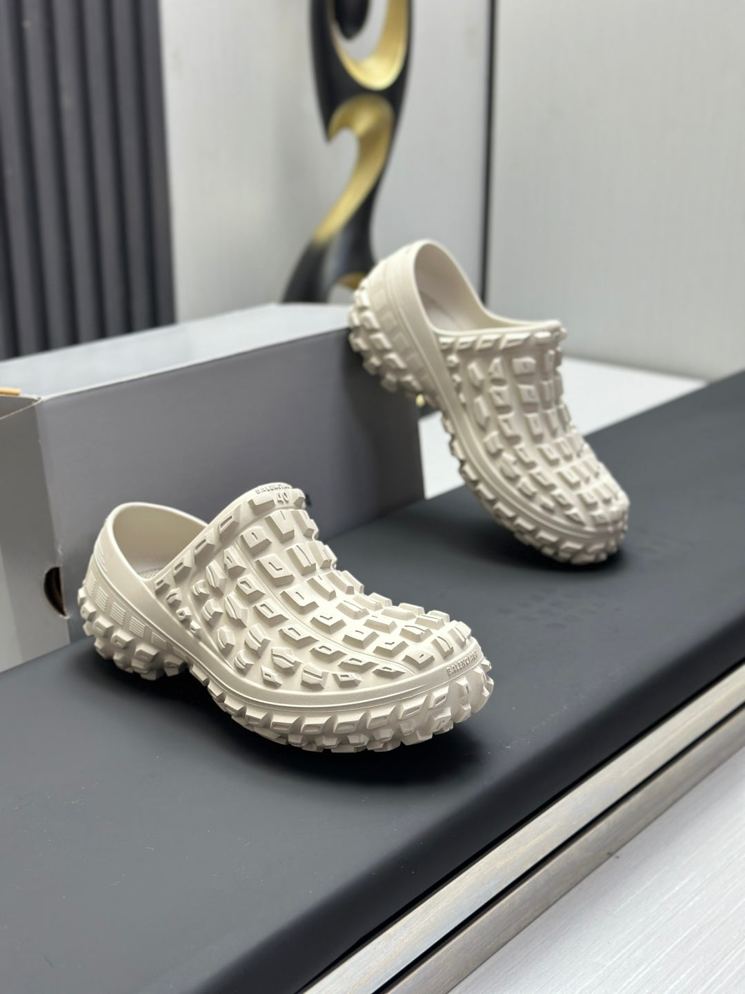 Balenciaga white slide sandals pair, angled view showing textured upper and thick sole