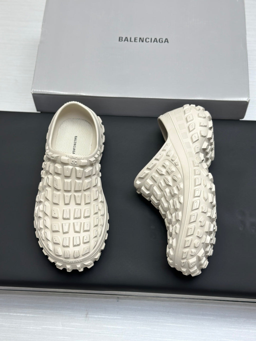 Balenciaga white slide sandals, front and outsole views on a box