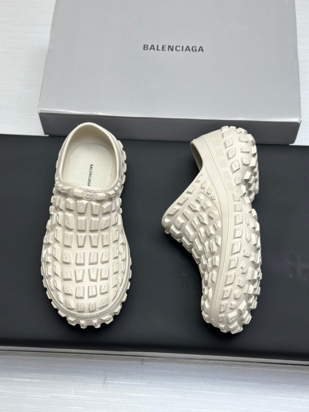 Balenciaga white slide sandals, front and outsole views on a box