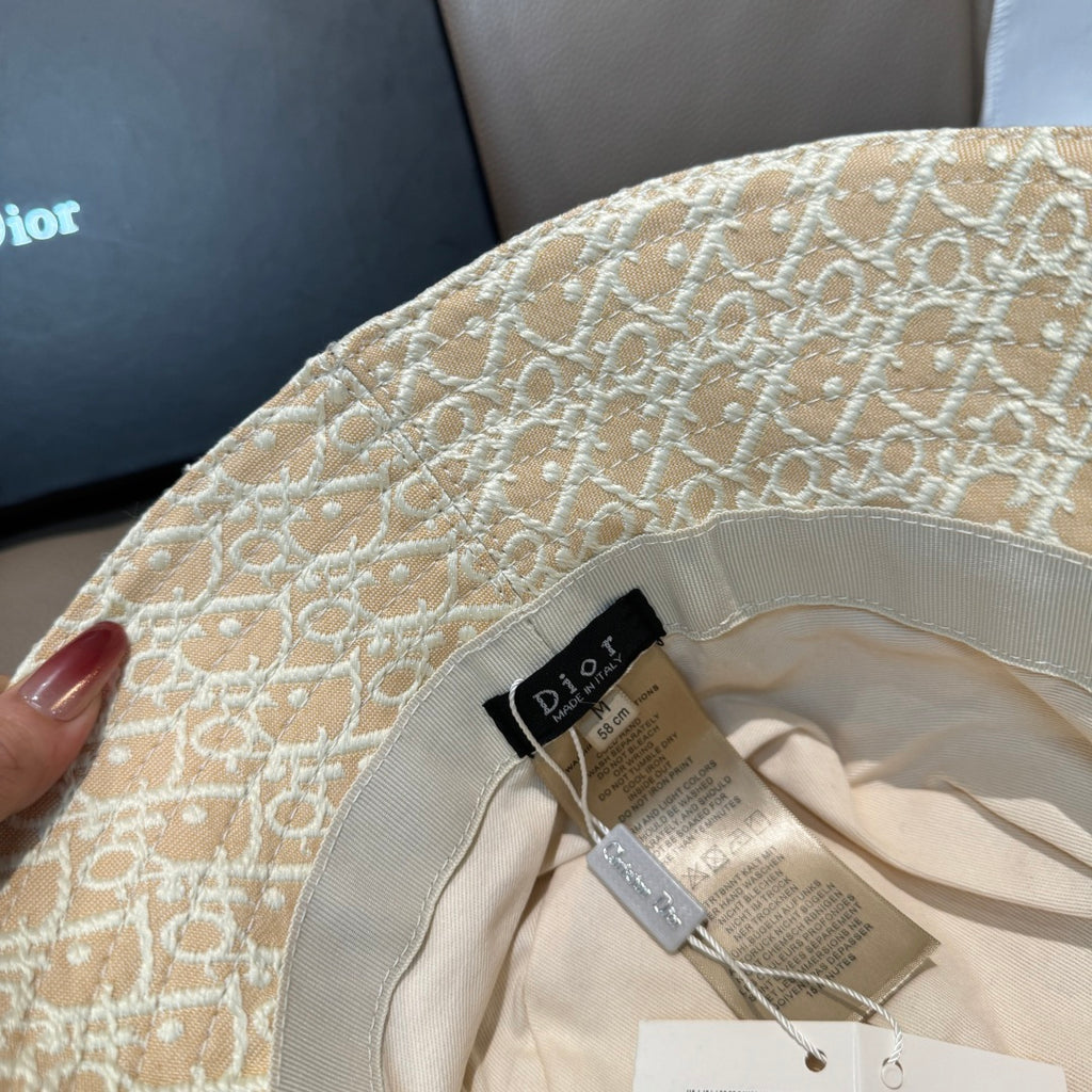 Dior bucket cap close-up showing tan monogram fabric and interior label